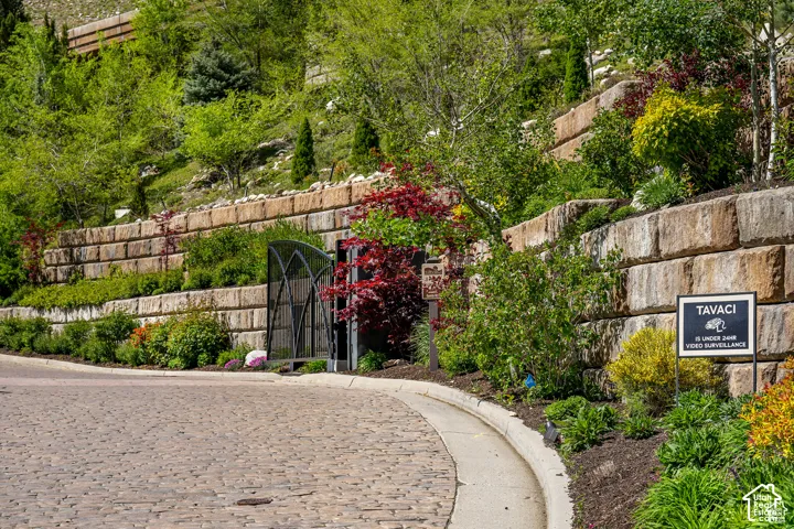 Cobblestone road leading to a landscaped hillside with tiered retaining walls