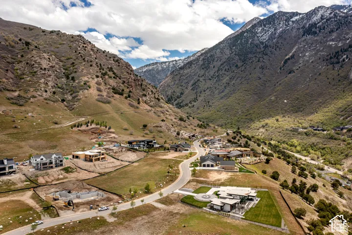 Mountainous terrain backdrop with residential development, winding roads, and varied topography
