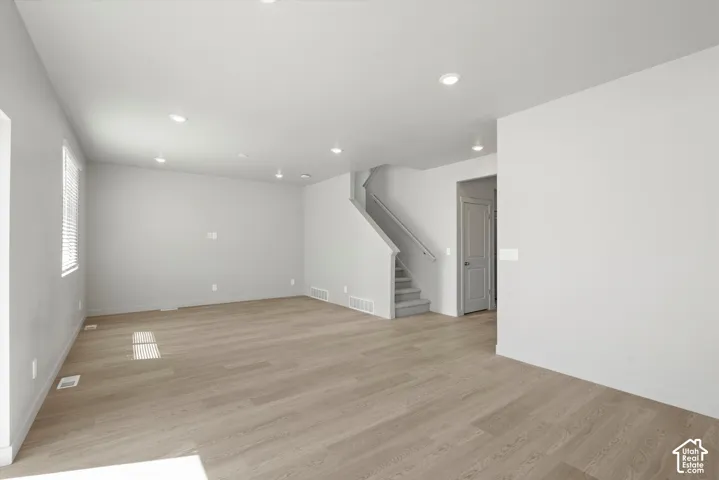 **DISLCAIMER**  Interiors do not show upgrades included. Recessed ceiling lighting, wood-finish flooring, a carpeted staircase with a wood handrail, and a window with blinds