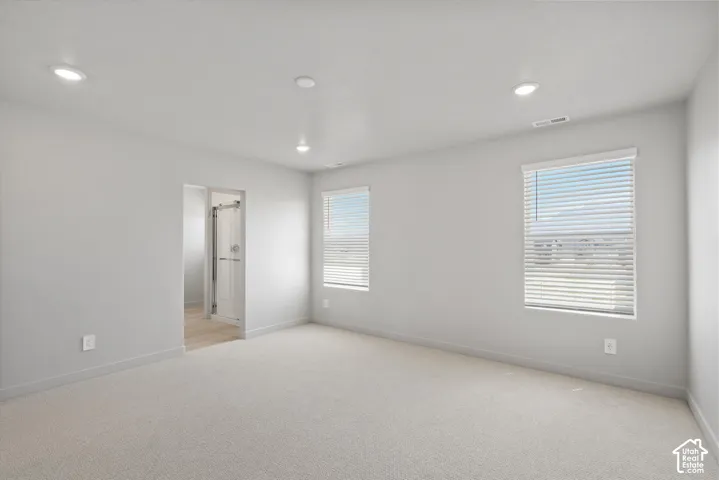**DISLCAIMER**  Interiors do not show upgrades included. Neutral tone walls, recessed lighting, two windows with blinds, light-toned carpeting, and an adjacent bathroom with a glass-enclosed shower