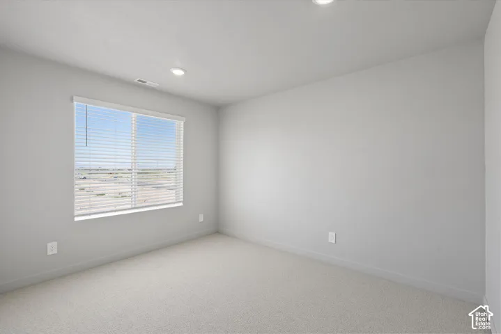**DISLCAIMER**  Interiors do not show upgrades included. Recessed lighting and a large window with blinds illuminate this carpeted room