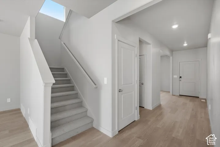 **DISLCAIMER**  Interiors do not show upgrades included. Staircase with light gray carpeting, wood-finish flooring, white paneled doors, and recessed lighting