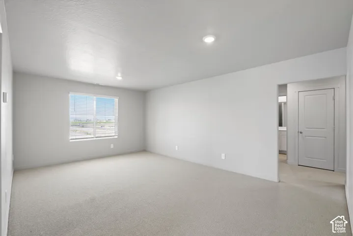 **DISLCAIMER**  Interiors do not show upgrades included. Open-concept room with light-colored carpeting, recessed lighting, and a large window with blinds