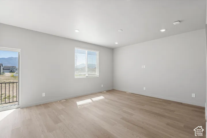 **DISLCAIMER**  Interiors do not show upgrades included. Recessed ceiling lighting, wood-finish flooring, white walls, large window with blinds, sliding glass door with a balcony