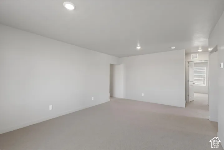 **DISLCAIMER**  Interiors do not show upgrades included. Recessed ceiling lighting illuminates a spacious room featuring neutral-toned carpeting and light-colored walls