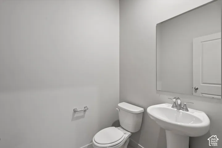 **DISLCAIMER**  Interiors do not show upgrades included. Pedestal sink with chrome faucet, wall-mounted mirror, and white toilet