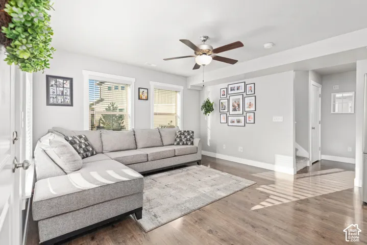 Recessed lighting, wood-finish flooring, ceiling fan with integrated light, multiple windows, and a staircase with carpeted treads