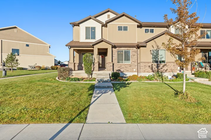 Two-story facade with stone and siding accents, covered front porch, and mature landscaping