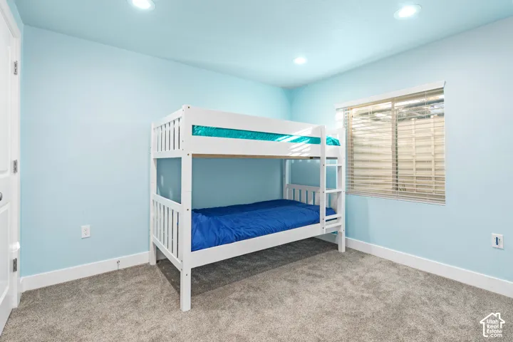 Recessed lighting, wall-to-wall carpeting, and a window with blinds