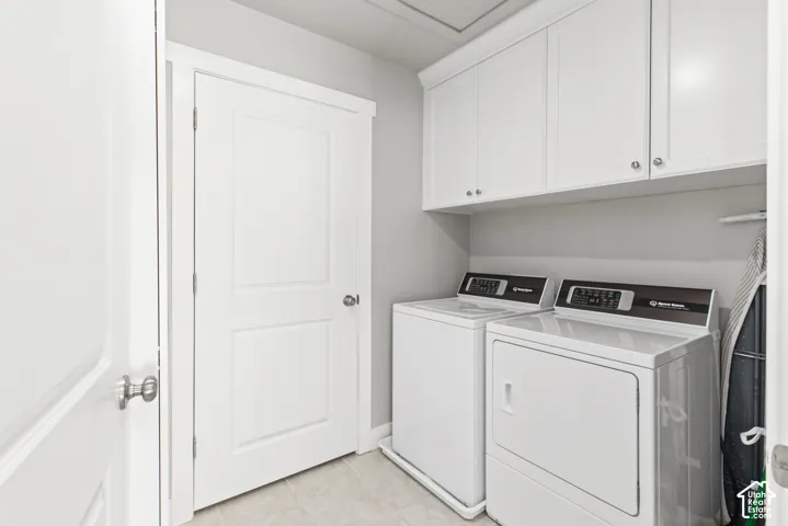 White shaker-style cabinetry with chrome hardware, light gray wall paint, and light-toned tile flooring