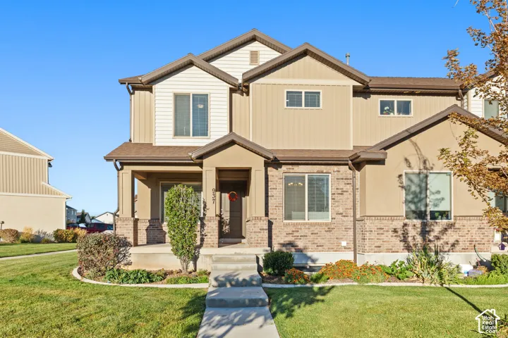Multi-level exterior featuring brick and stucco finishes, covered entry, and a covered porch
