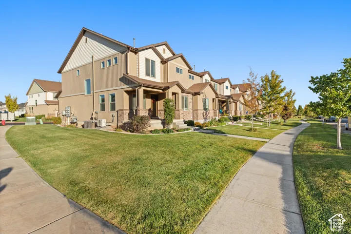 Exterior featuring multiple units with mixed material siding, covered entryways, and a concrete pathway
