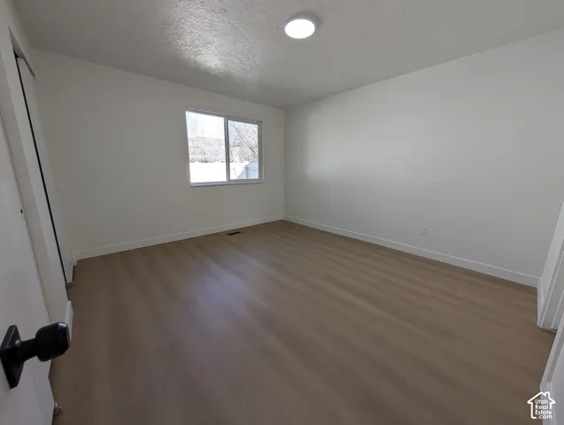 Wood-finish flooring, white walls, and a recessed ceiling light create a bright atmosphere