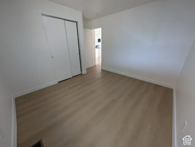 Neutral wall color, wood-finish flooring, and built-in closet with sliding doors