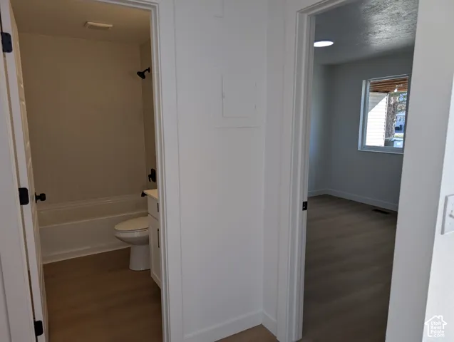 Bathroom featuring a white tub, white tiled surround, and matte black fixtures