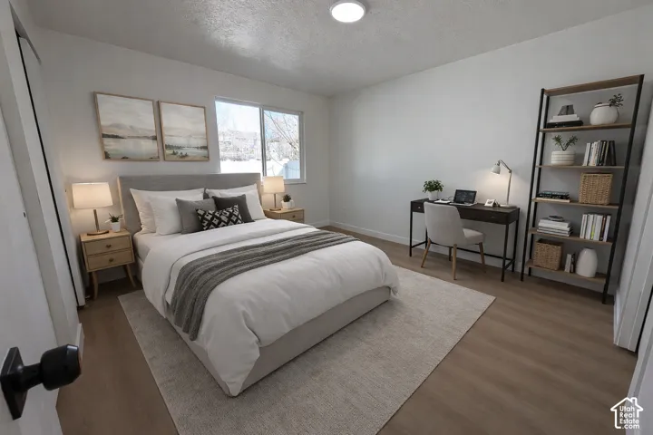 Wood-finish flooring, white walls, built-in closet, and a recessed ceiling light