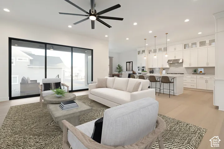 Open-concept living area with wood-finish flooring, a contemporary ceiling fan, and large sliding glass doors