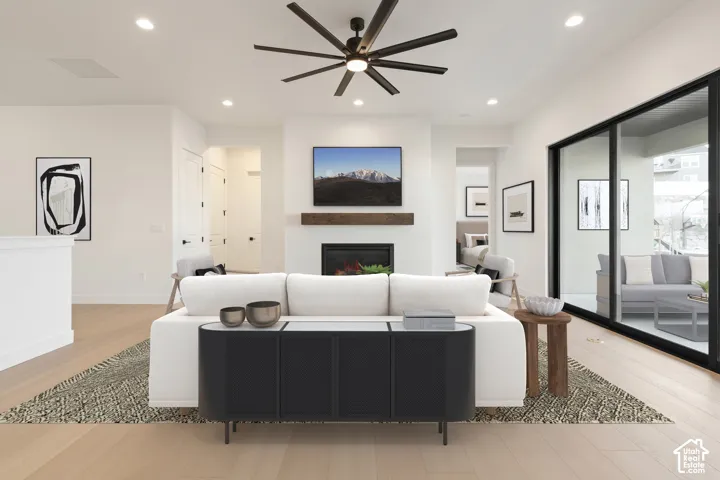 Recessed lighting, wood-finish flooring, and a fireplace with a wood mantle