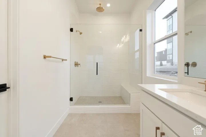 Glass-enclosed shower with a built-in bench, ceiling-mounted shower head, and an additional wall-mounted shower head