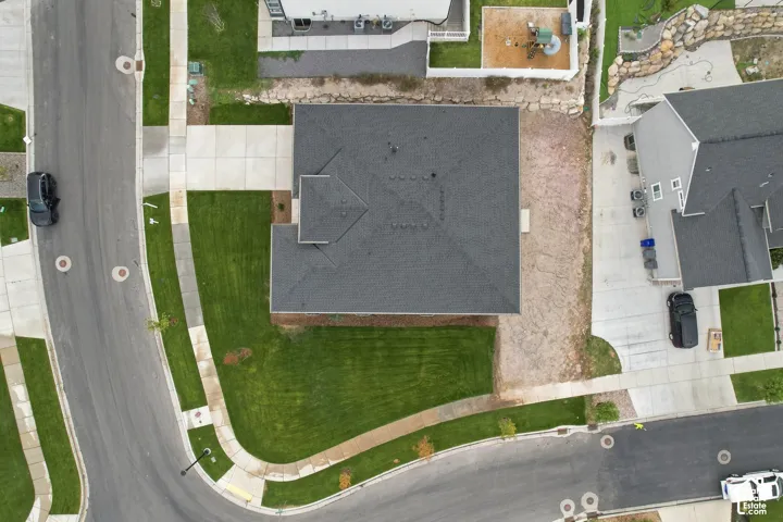 Pitched roof design, concrete driveway, and front lawn
