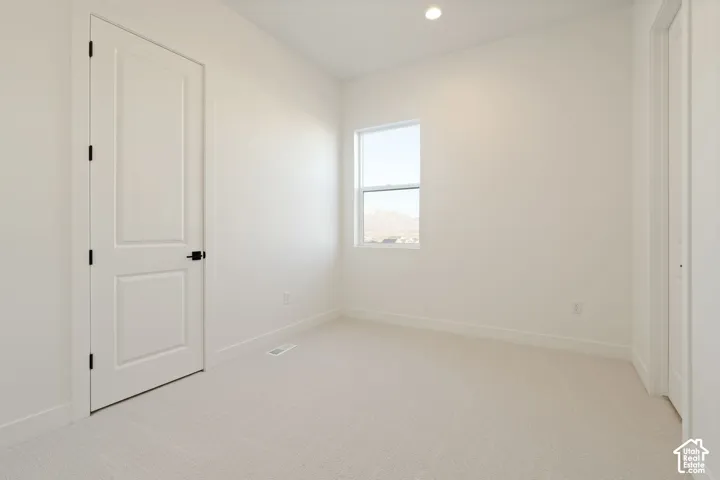 Neutral color palette with light-toned carpeting and a single window
