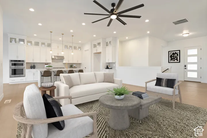 Open-concept living area with wood-finish flooring, recessed lighting, and a contemporary ceiling fan
