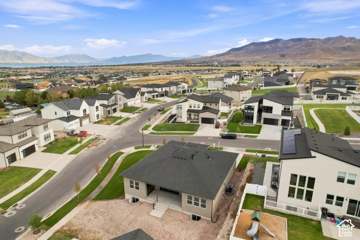 Contemporary suburban development featuring paved roads, manicured lawns, and modern home designs with dark roofs