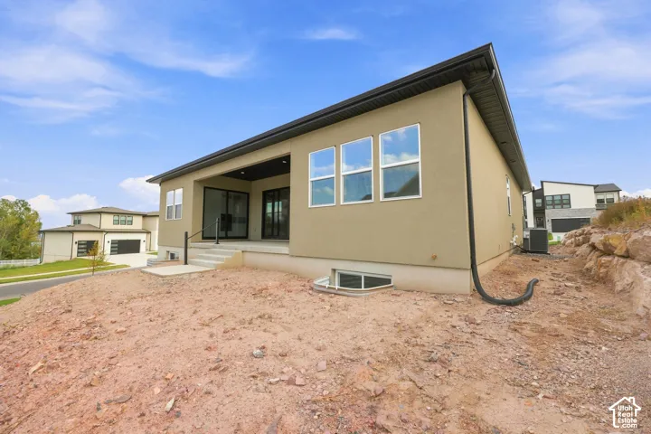 Contemporary exterior with a covered patio, multiple windows, and a foundation window