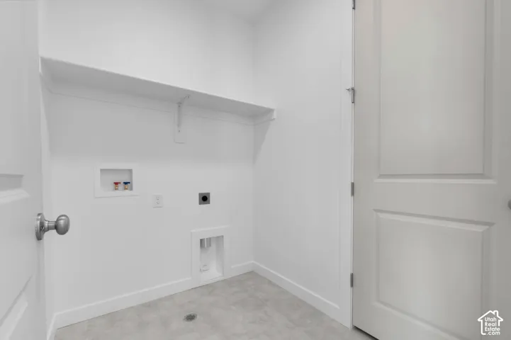 Laundry area featuring a utility sink connection, dryer vent, and wall-mounted shelving