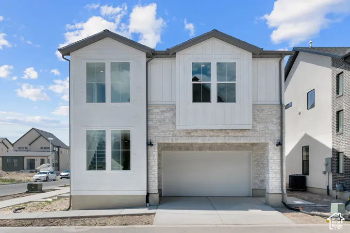 Modern exterior with white vertical siding, light-toned stone veneer accents, and a dark-pitched roof