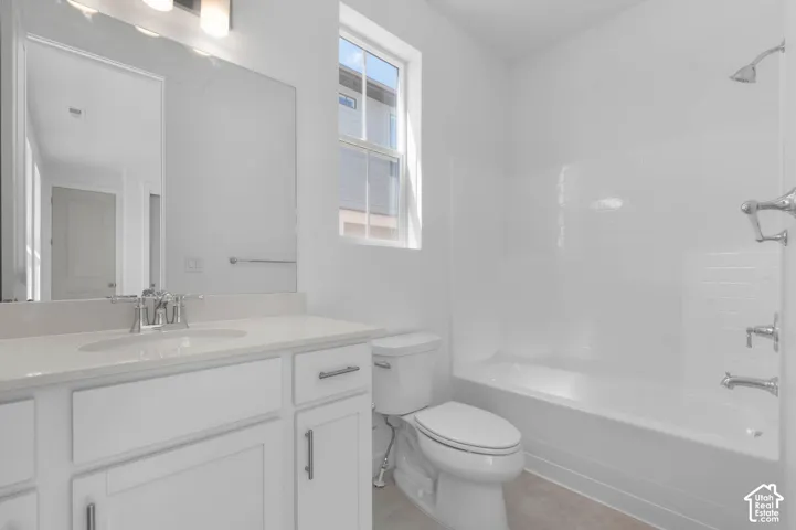White vanity with quartz countertop, undermount sink, and chrome faucet