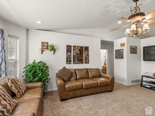 Recessed lighting, sloped ceiling, built-in ceiling fan with chandelier, carpeted flooring, and a window with blinds