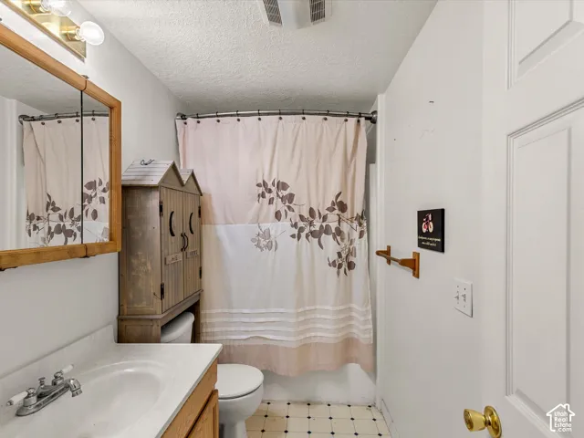 White ceramic sink with chrome faucet, light wood-finish vanity, and a wood-framed mirror