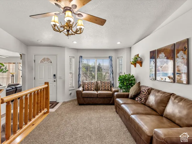 Recessed lighting, ceiling fan light fixture, bay window, white paneled door with arched glass insert, and carpet flooring