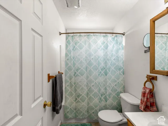 Compact bathroom with a white paneled door, a standard toilet, and a vanity with a counter