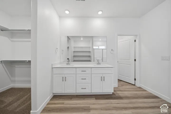 Dual vanity with white shaker-style cabinetry and a large integrated mirror
