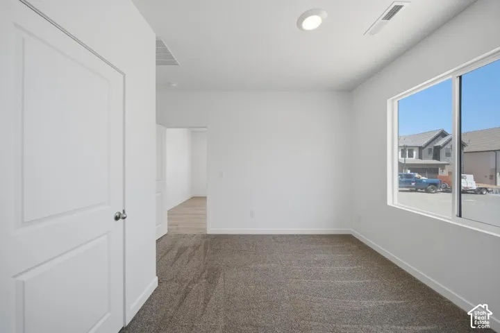 White walls, recessed lighting, and a large window