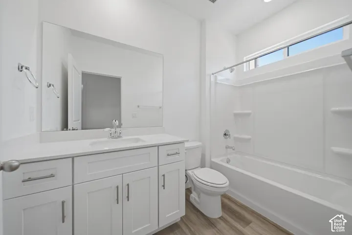 White vanity with shaker-style cabinetry, an undermount sink, and a quartz countertop