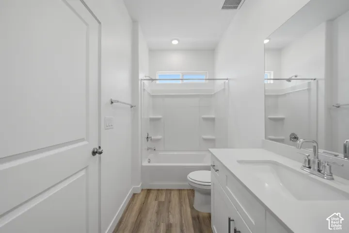 Wood-finish flooring with a white vanity featuring a polished chrome faucet
