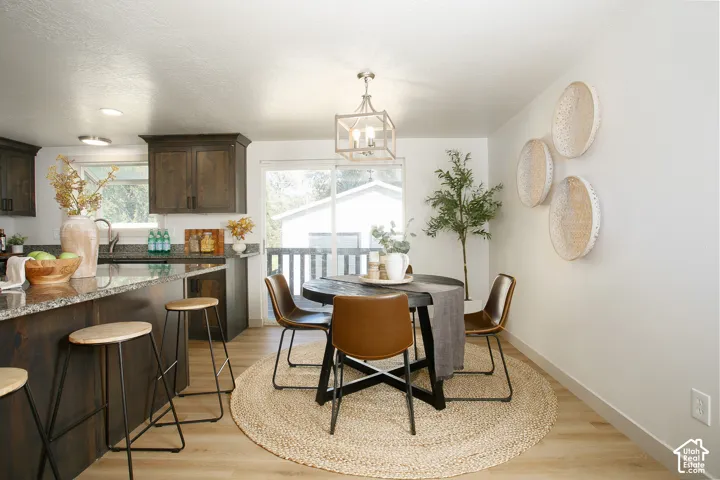 Wood-finish flooring throughout, dark wood cabinetry, granite countertops, recessed lighting, and a sliding glass door