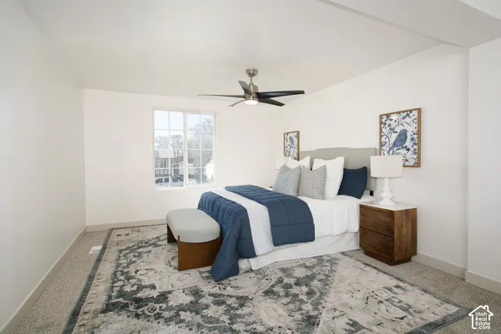 Recessed lighting, ceiling fan, white walls, carpet flooring, and a large window