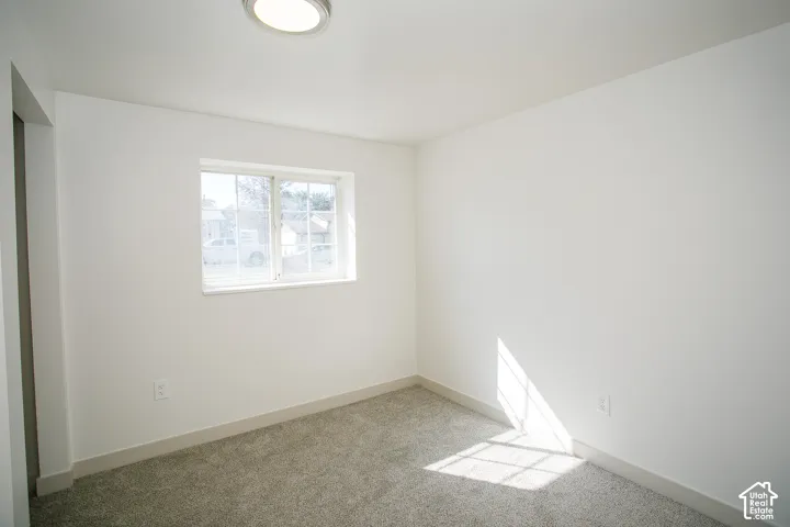 Crisp white walls, neutral carpeting, and a flush-mount ceiling light fixture