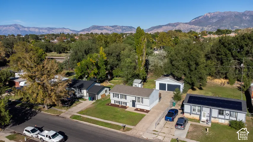 Mountain backdrop, mature trees, paved driveways, detached garage, solar panels