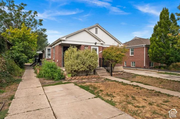 Brick exterior with white trim, covered front entry, and concrete walkway
