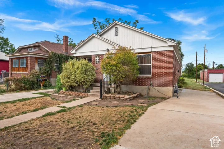Brick exterior with white trim, concrete driveway, and front walkway
