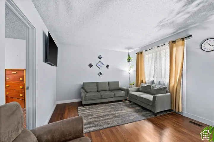 Wood-finish flooring throughout, light-toned walls, and a wall-mounted television