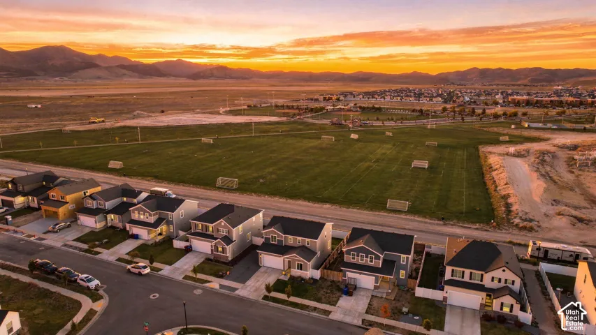Neighborhood with multiple residential structures, paved streets, and a manicured green space