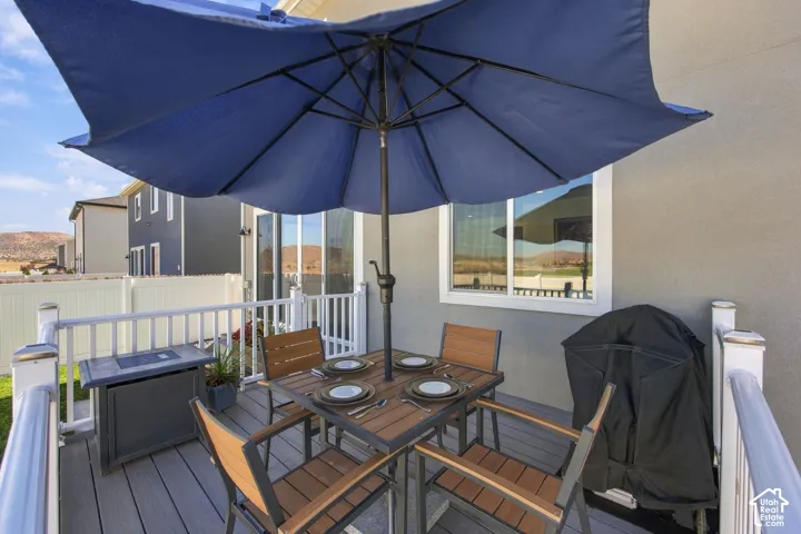 Outdoor deck with a white railing, featuring sliding glass doors and a large window