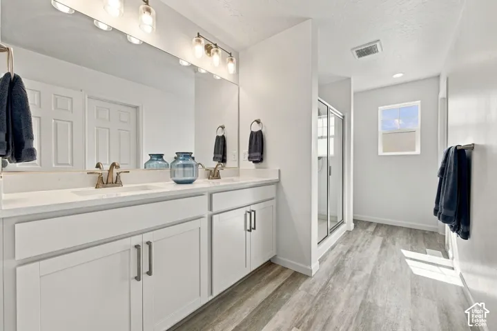 Primary bathroom. Double vanity with quartz countertop, dual sinks, and bronze-finish faucets