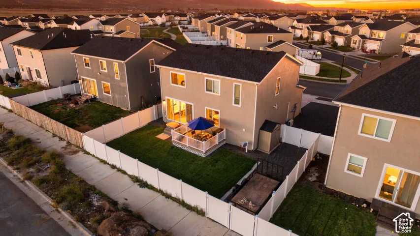 Expansive backyard featuring a manicured lawn, a raised wood deck, and white vinyl fencing
